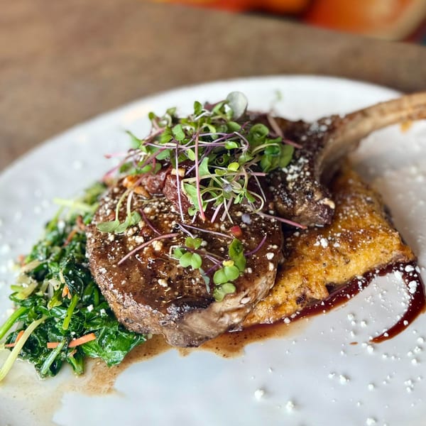 Amaya's Fresh Mexican Grill's pork chop with microgreens, sauce, and a side of green vegetables.
