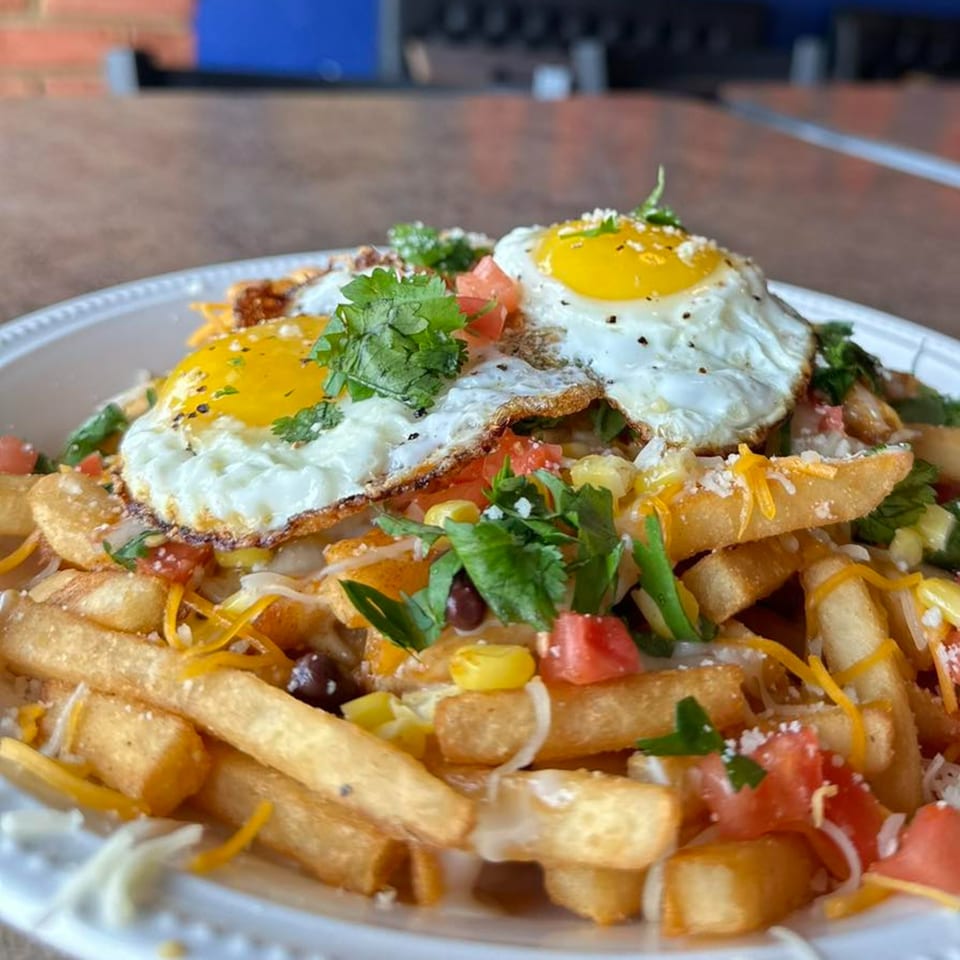 Amaya's Fresh Mexican Grill's breakfast fries topped with two fried eggs, cheese, and fresh vegetables.